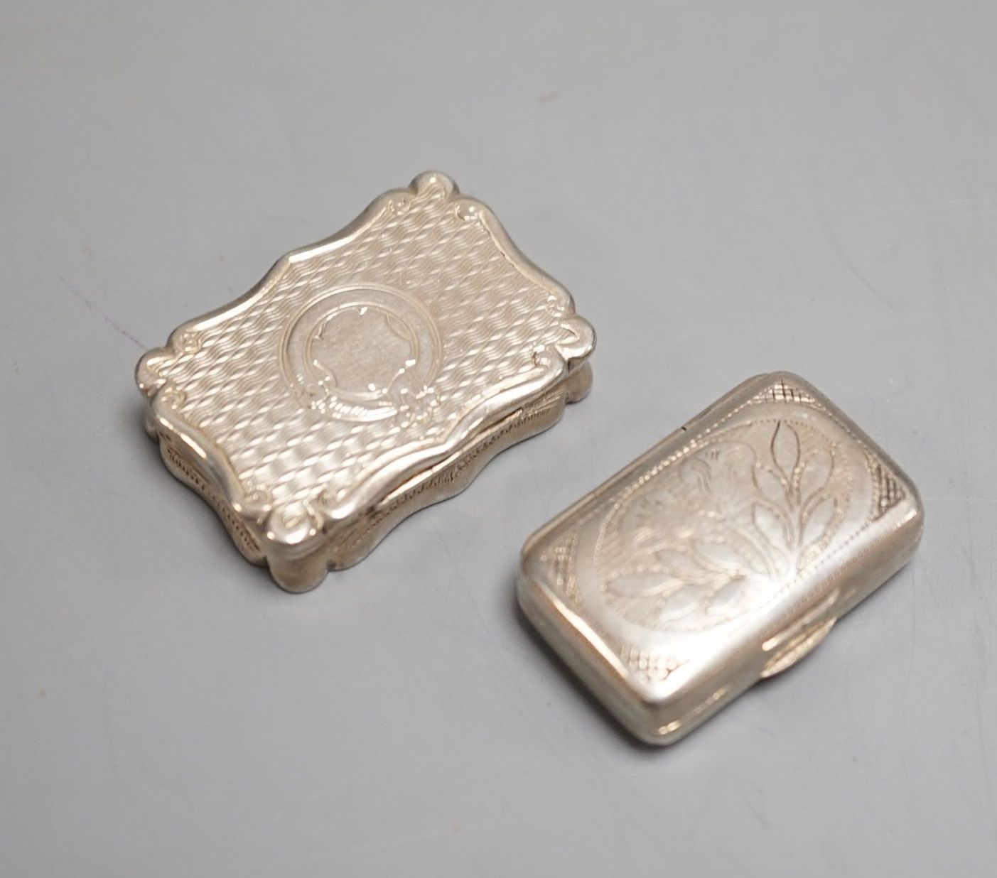 A George III engraved silver rectangular vinaigrette, by Wardell & Kempson, Birmingham, 1811, 27mm and a later silver vinaigrette by Frederick Marsen, Birmingham, 1868, 30mm.